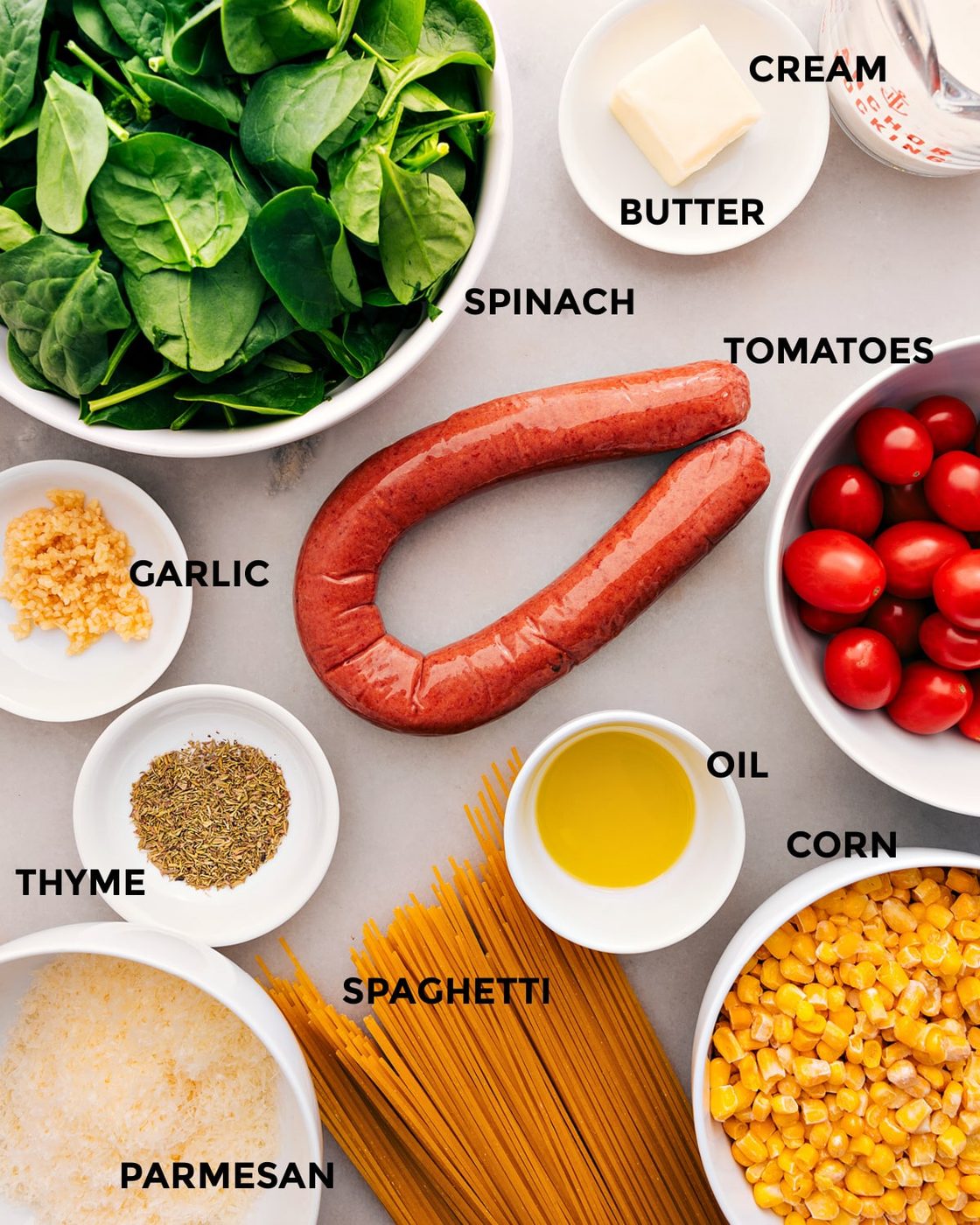 Ingredients prepped for straightforward assembly: veggies, meat, spaghetti, seasonings, oil, and parmesan.