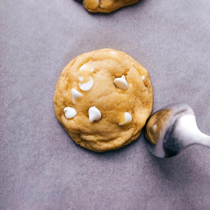 A freshly baked cornmeal cookie, rounded by using the back of a spoon while still warm, ready to be enjoyed as a satisfying treat.