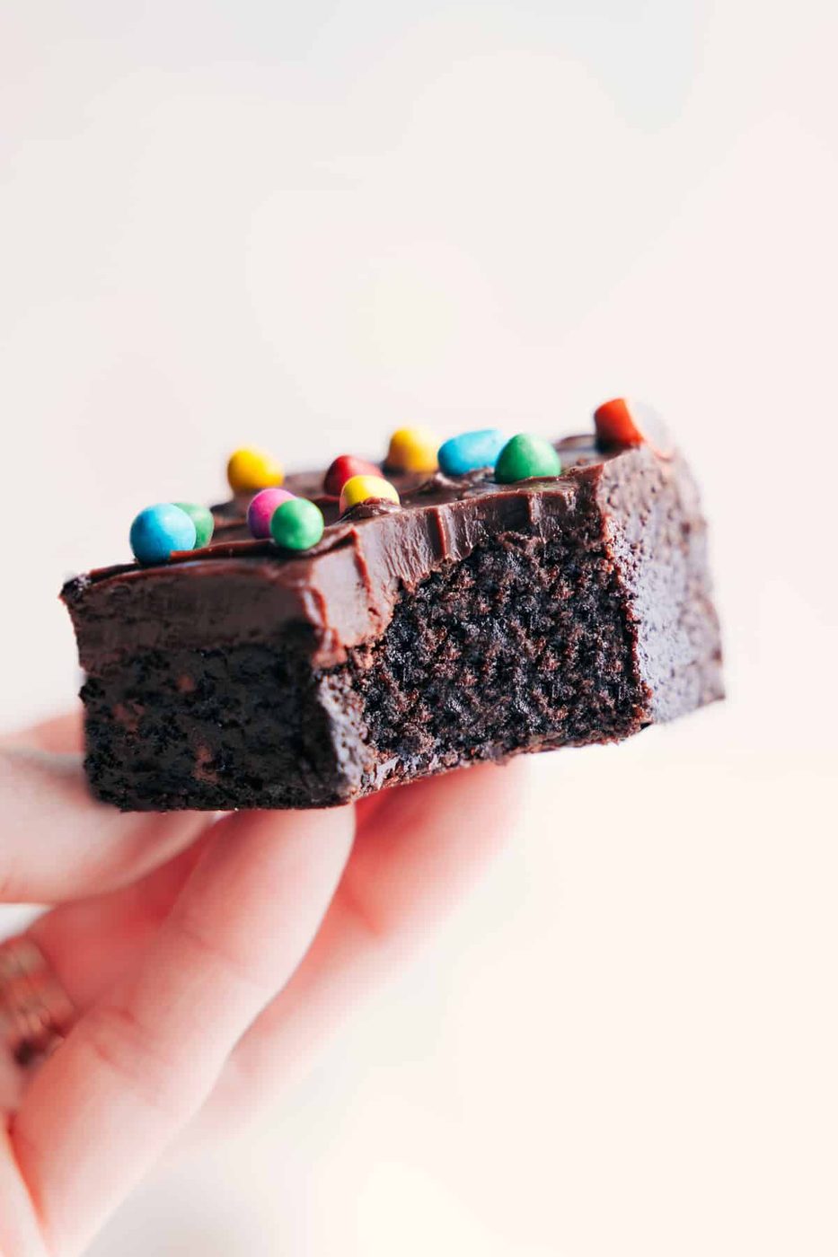 Cosmic Brownies Recipe held up with a large bite taken out of one brownie.