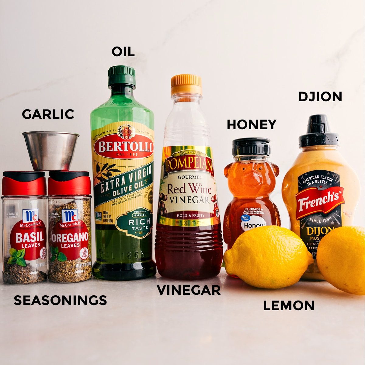 Dressing ingredients prepped for straightforward assembly: seasonings, oil, mustard, honey, lemon, and garlic.
