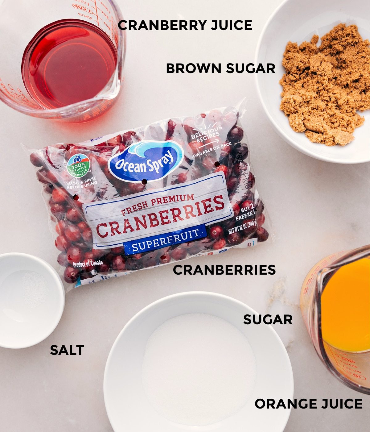 This recipe's ingredients are prepped for straightforward assembly: cranberries, sugar, orange juice, brown sugar, cranberry juice, and salt.