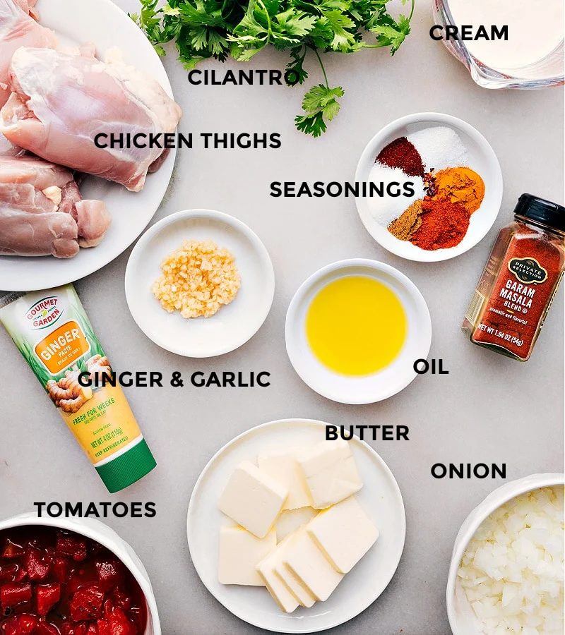 All the ingredients for this recipe are prepped and ready for straightforward assembly: chicken, oil, spices, tomatoes, onions, garlic, ginger, and butter.