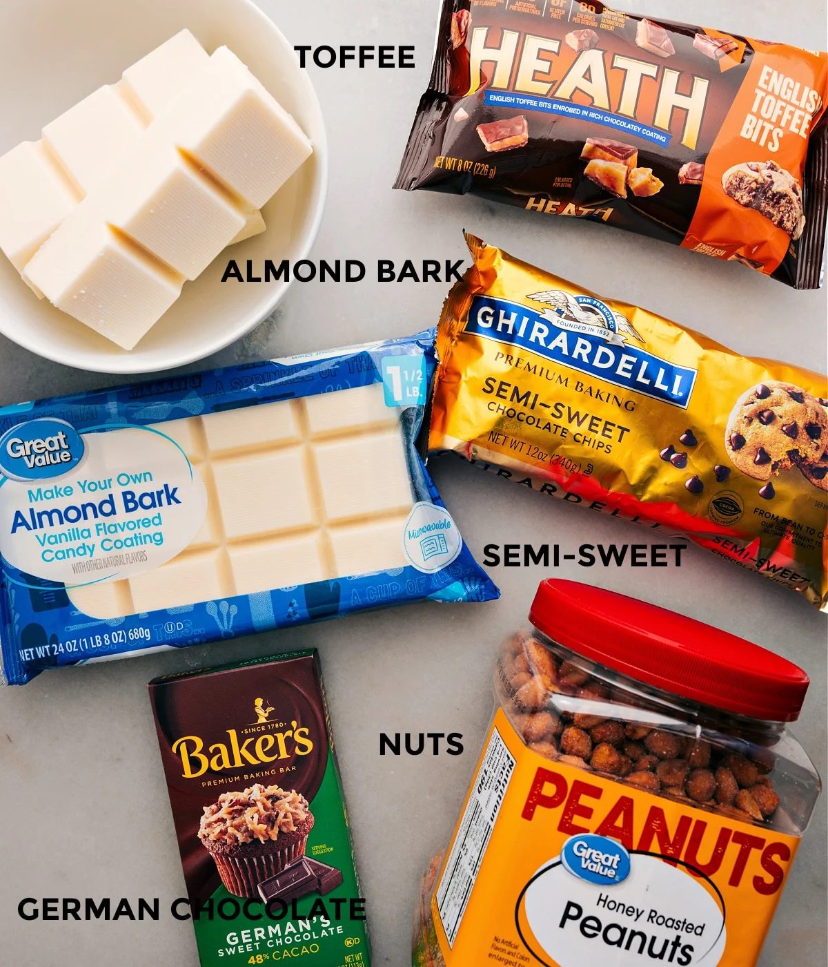 Ingredients ready for straightforward assembly: almond bark, chocolate chips, German chocolate, nuts, and Heath toffee bits.