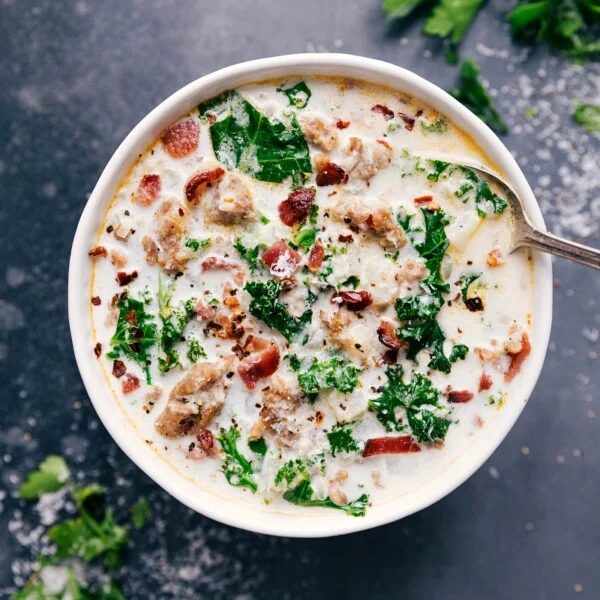 A bowl of straightforward Zuppa Toscana soup topped with fresh herbs.