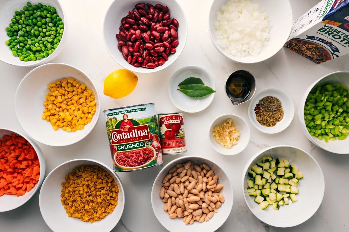 Ingredients prepped for straightforward assembly, including peas, beans, pasta, crushed tomatoes, tomato paste, garlic, and vegetable broth.