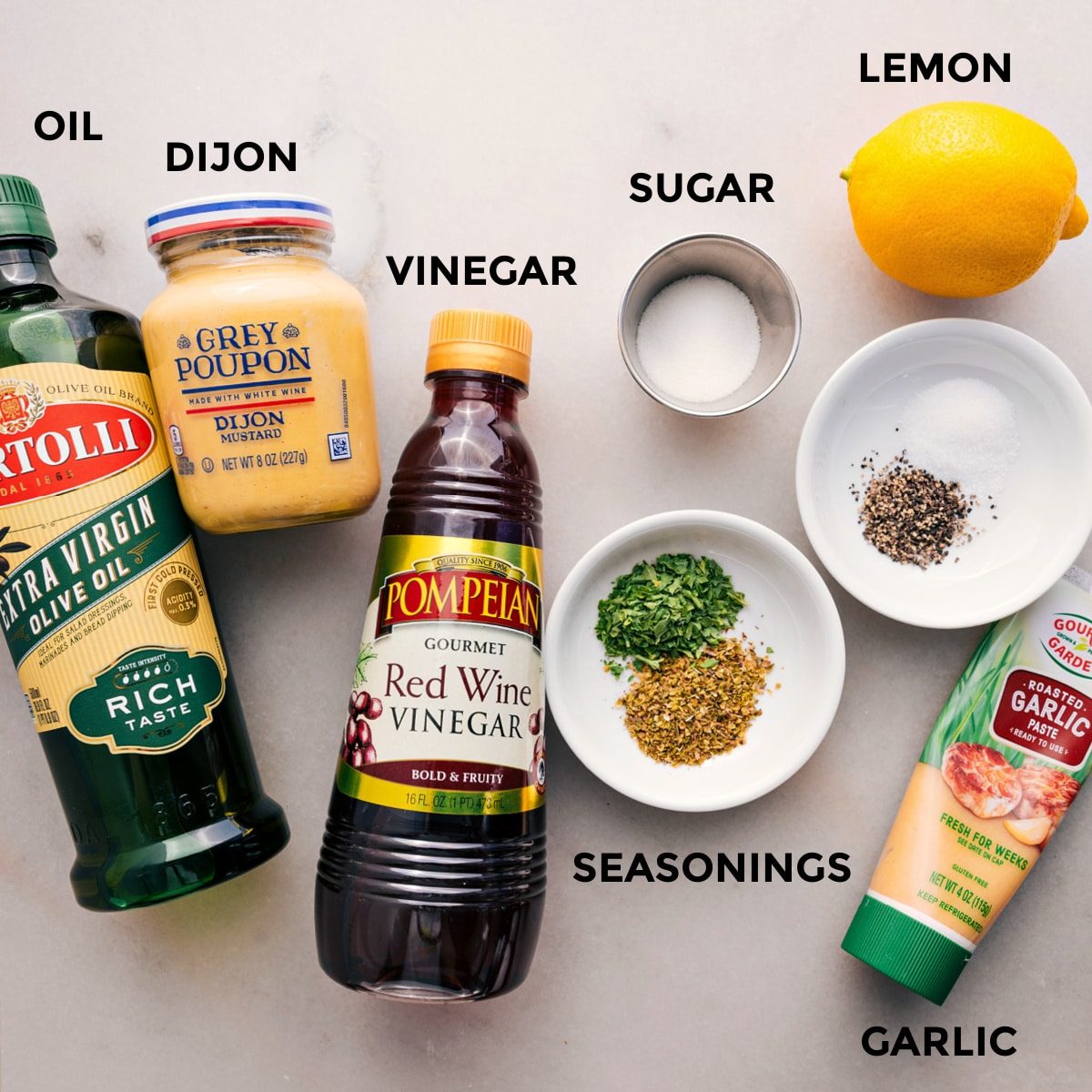 All the dressing ingredients for the dense bean salad are prepped and ready for straightforward assembly: oil, Dijon, vinegar, sugar, seasonings, garlic, and lemon.