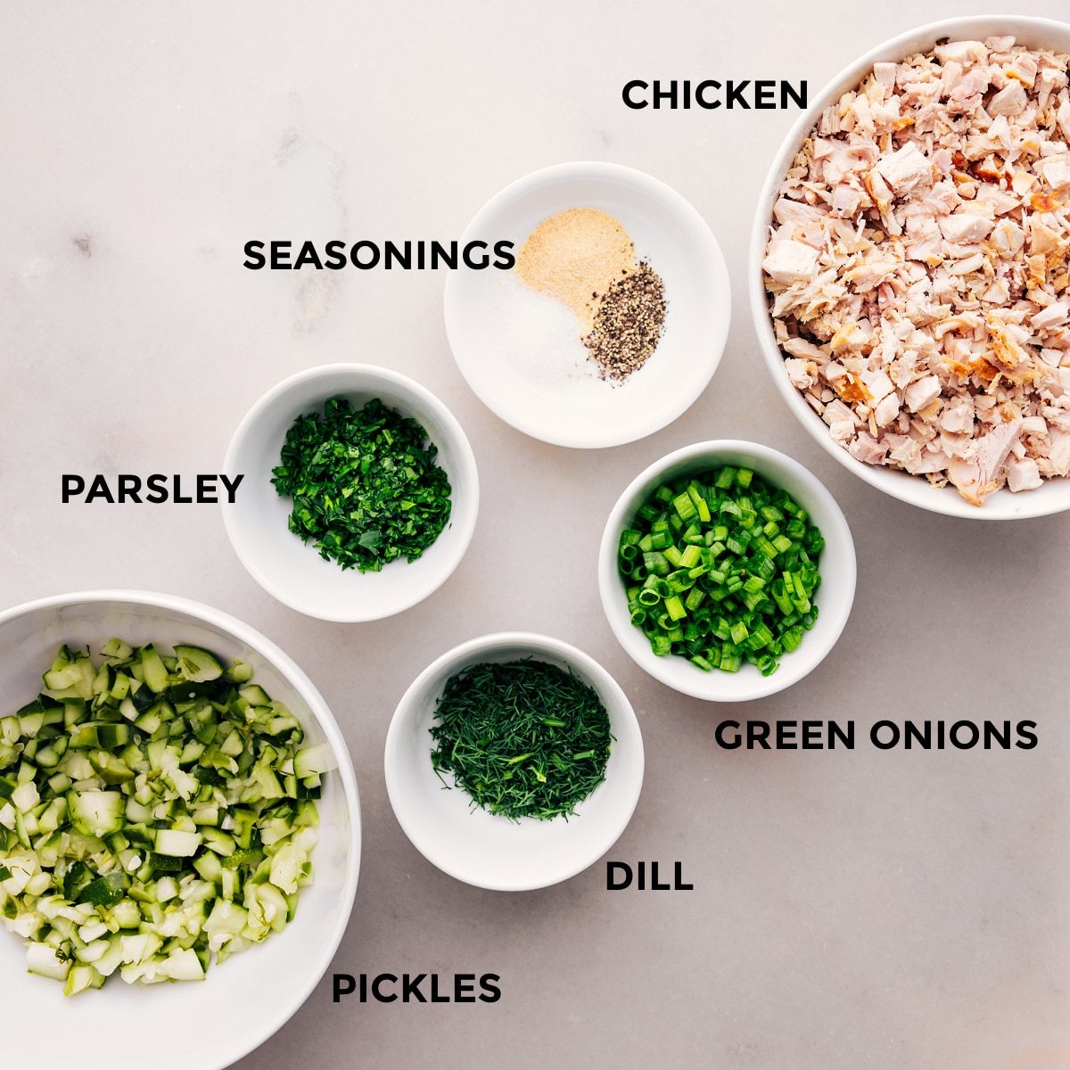 Prep all the dill pickle chicken salad ingredients for straightforward assembly: chicken, green onions, dill, parsley, pickles, and seasonings.