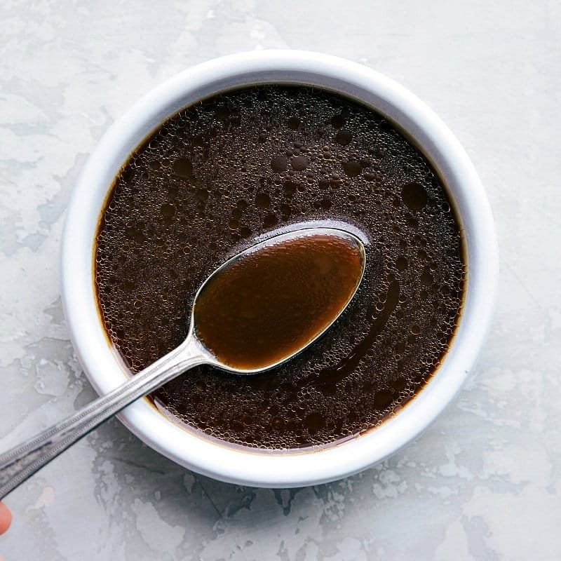 A flavorful sauce being poured over the meal, enhancing the dish with rich and savory flavors.