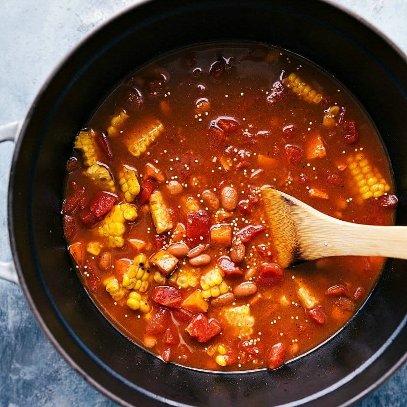 Vegetables and beans being added to the pot and mixed together, blending satisfying and complementary flavors.