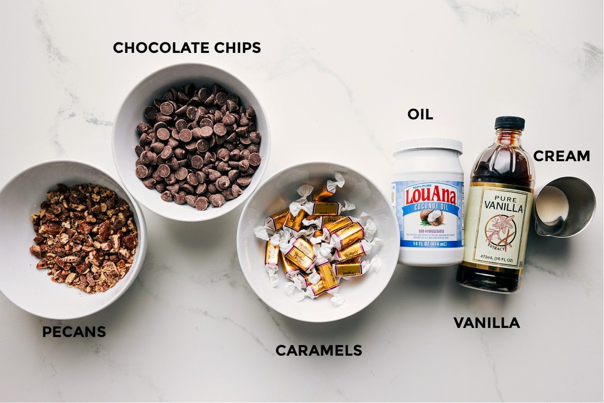 All the ingredients in this recipe prepped for straightforward assembly including the pecans, chocolate chips, caramels, oil, vanilla, and cream.