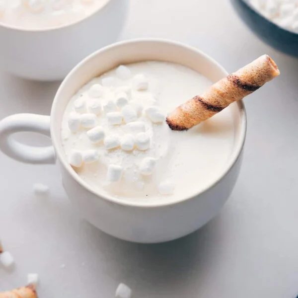 The finished white hot chocolate beverage in a mug, topped with mini marshmallows, a satisfying and beautiful drink ready for enjoyment on a cold day.