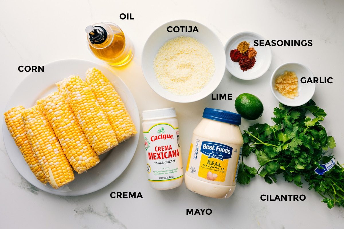 All the ingredients in this recipe prepped out for straightforward assembly including the corn, oil, cotija, crema, mayo, cilantro, garlic, lime, and seasonings.