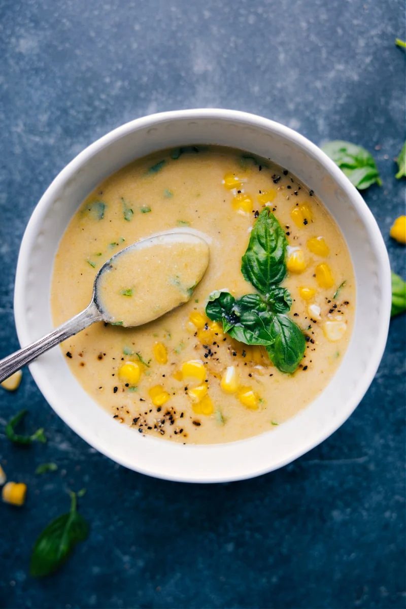 Fresh corn soup with sweet corn and basil in a creamy bowl.