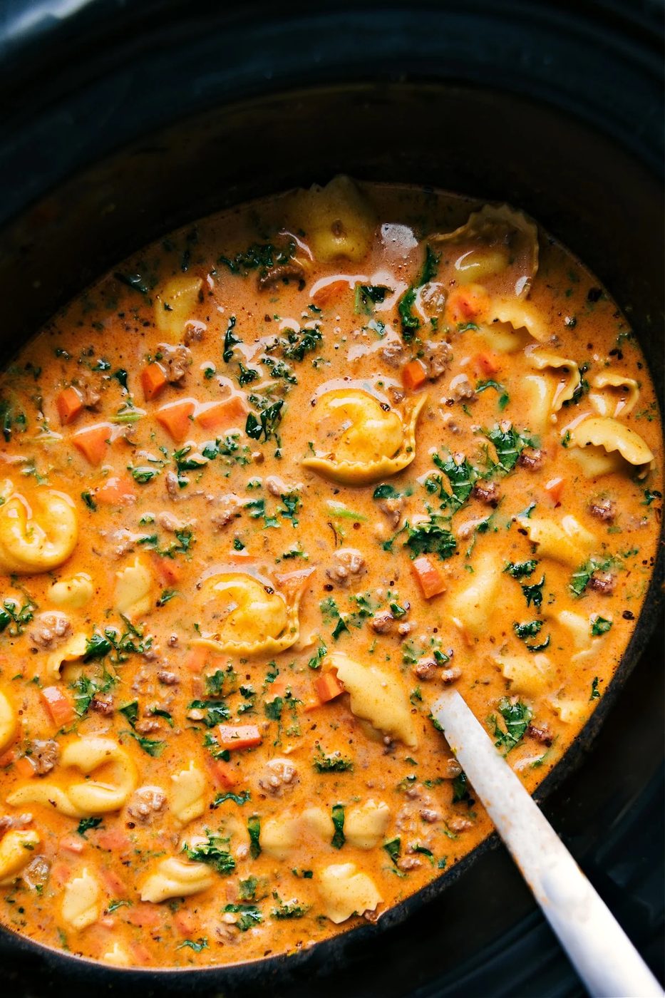 slow cooker tortellini soup with cheese tortellini, Italian sausage, and creamy tomato broth.