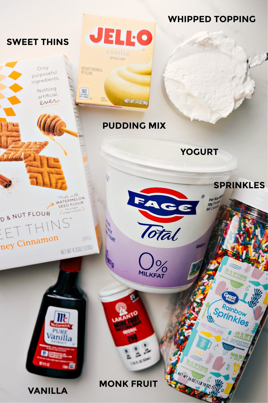 All the ingredients prepped for straightforward assembly, including graham crackers for dipping, yogurt, sprinkles, monk fruit sweetener, and vanilla.
