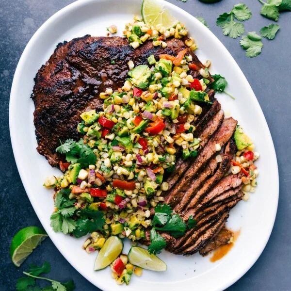 Sliced flank steak with corn salsa showing the evenly cooked interior, creating a deliciously complimentary meal.
