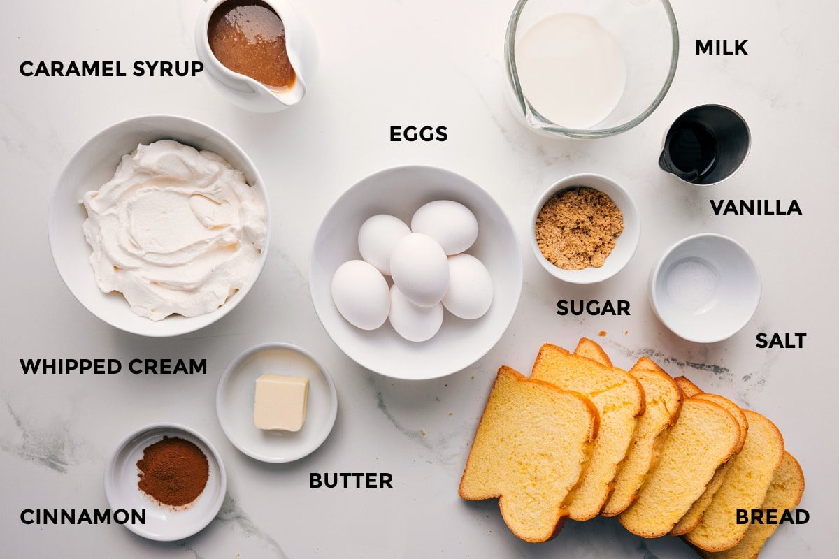 All the ingredients in this recipe prepped out for straightforward assembly including the whipped cream, cinnamon, butter, bread, eggs, sugar, salt, vanilla, milk, and syrup.