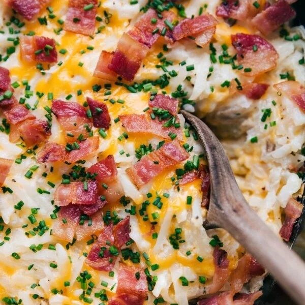 A warm, hearty scoop of slow cooker hashbrown casserole, steaming and ready to be served.