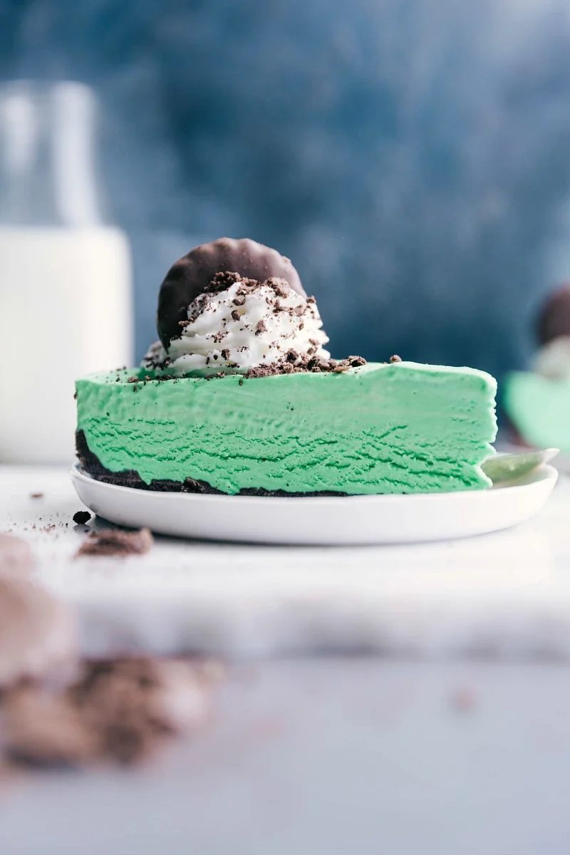 Thin mint cheesecake topped with whipped cream and a cookie finish.