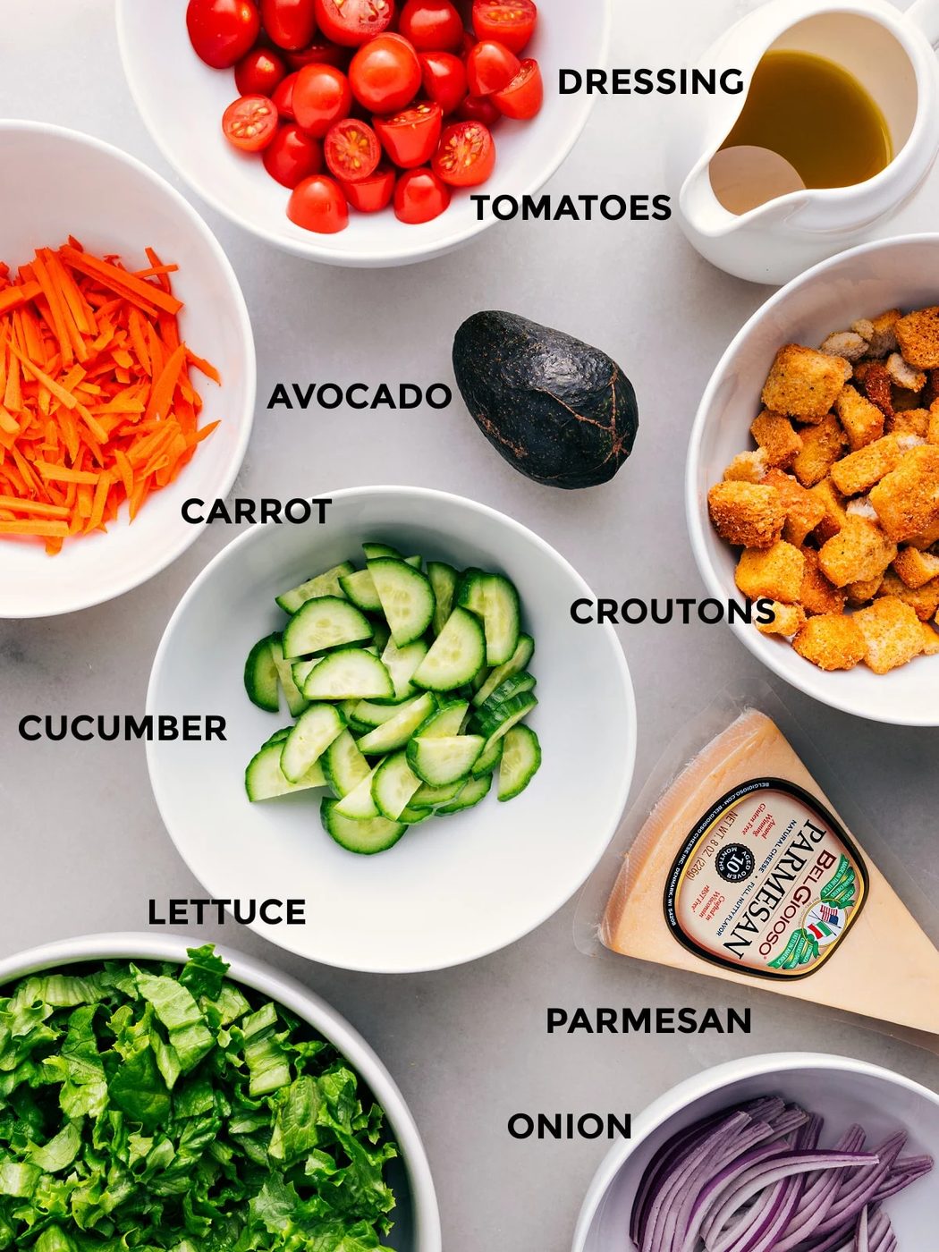 Prep the avocado, lettuce, Parmesan, croutons, cucumbers, tomatoes, and dressing for straightforward assembly.