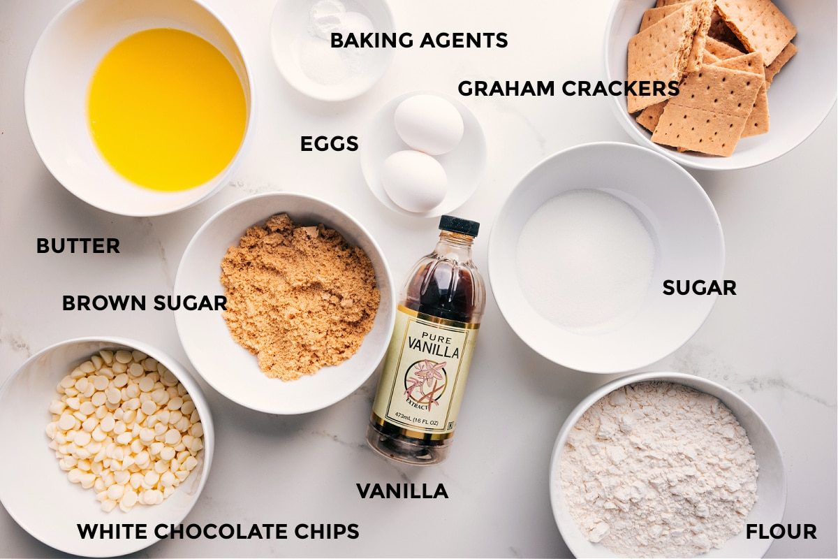 All the ingredients in this recipe prepped out for straightforward assembly including the butter, brown sugar, white chocolate chips, baking agents, eggs, graham crackers, sugar, vanilla, and flour.
