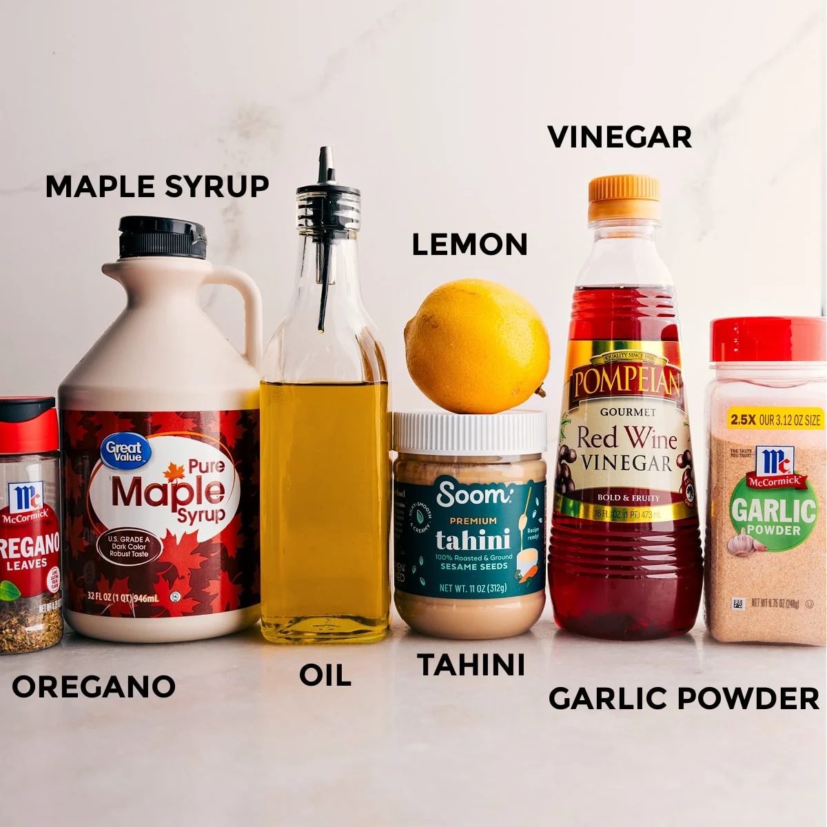 The dressing ingredients for the grain bowl—maple syrup, seasonings, lemon, tahini, and vinegar—are prepped for straightforward assembly.