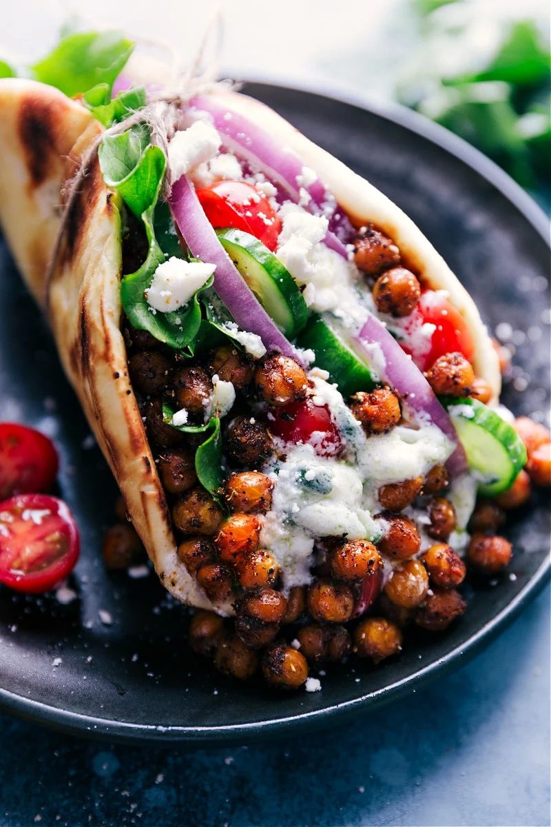 Vegetarian gyros in a pita topped with fresh veggies and tzatziki.