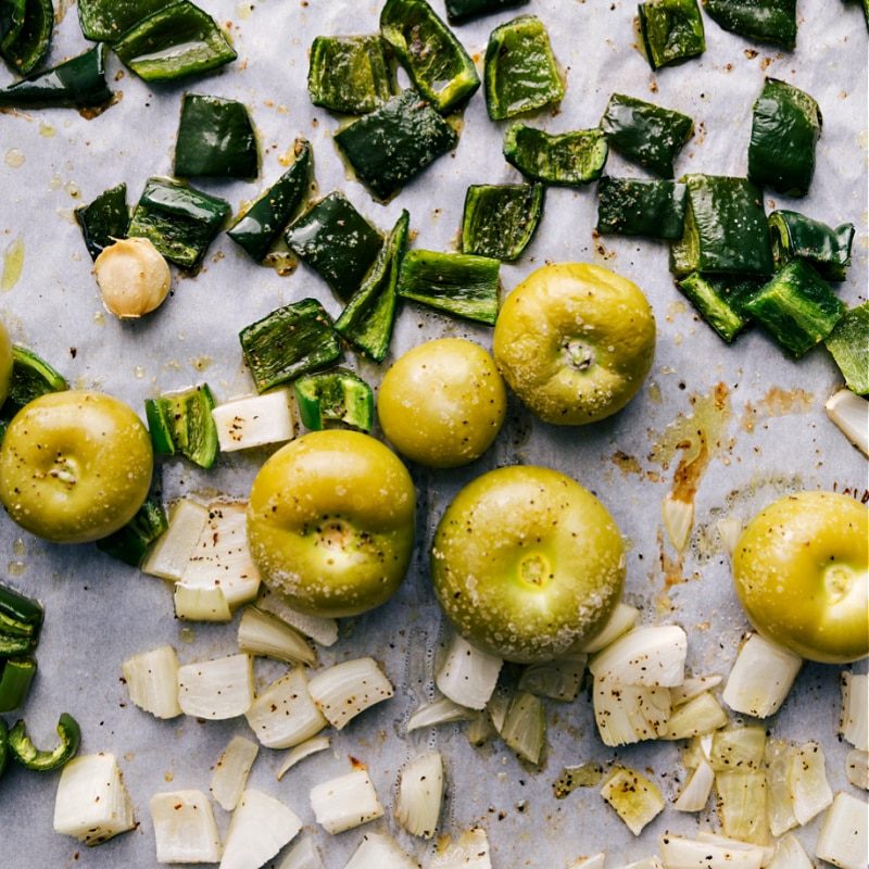 The roasted peppers, tomatillos, onions and garlic on a sheet pan fresh out of the oven for green enchilada sauce.