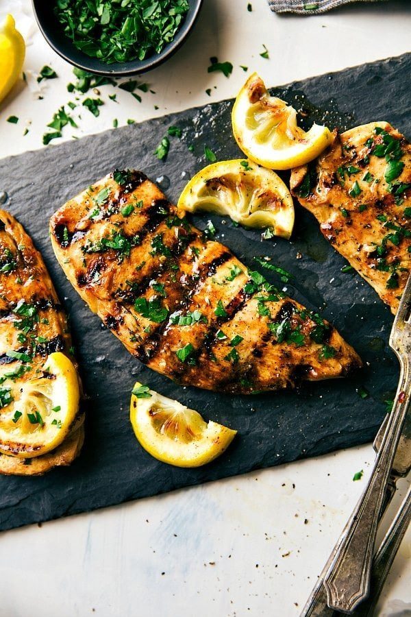Grilled chicken covered in flavorful chicken marinade and topped with fresh herbs, evenly cooked and full of flavor.
