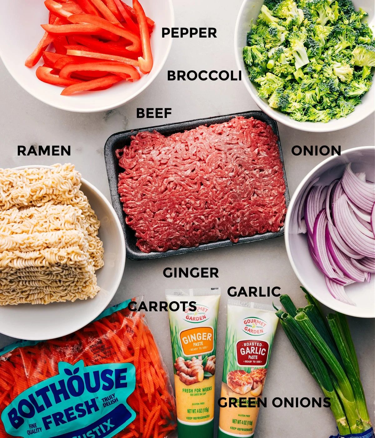 All the ingredients for this recipe are prepped and ready to go—peppers, broccoli, meat, onion, noodles, ginger, garlic, green onions, and carrots.