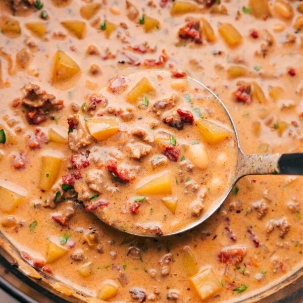 A pan filled with the finished tuscan sausage & potato soup, full of flavor and ingredients, warm and ready to be enjoyed as a satisfying meal.