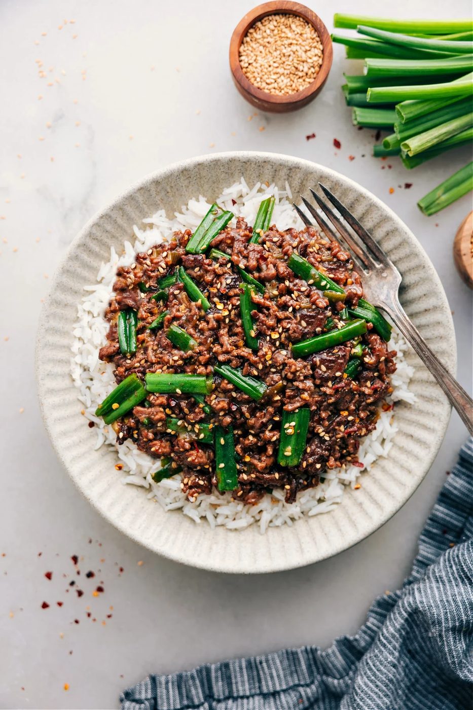 Healthy ground beef recipes Mongolian ground beef in a skillet with green onions and savory stir fry sauce.