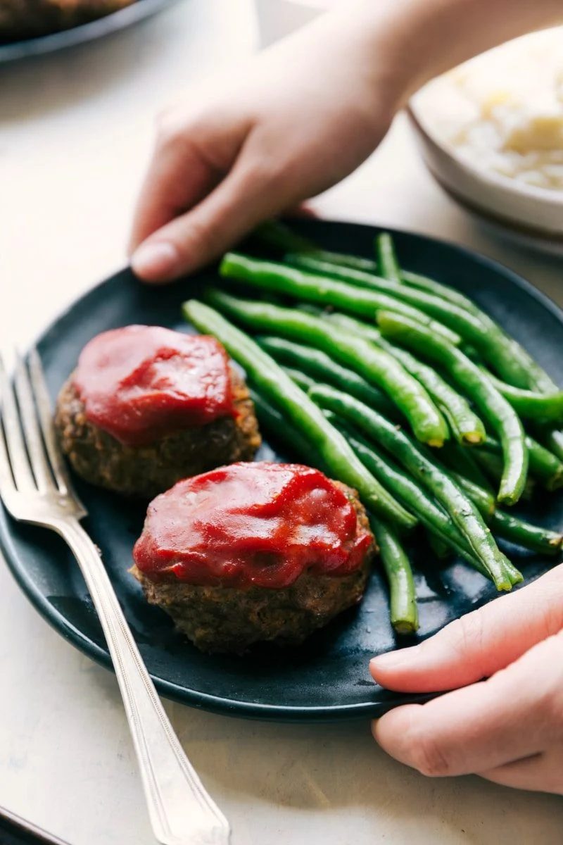 Healthy ground beef recipes: one pan mini meatloaf on a plate with green beans.