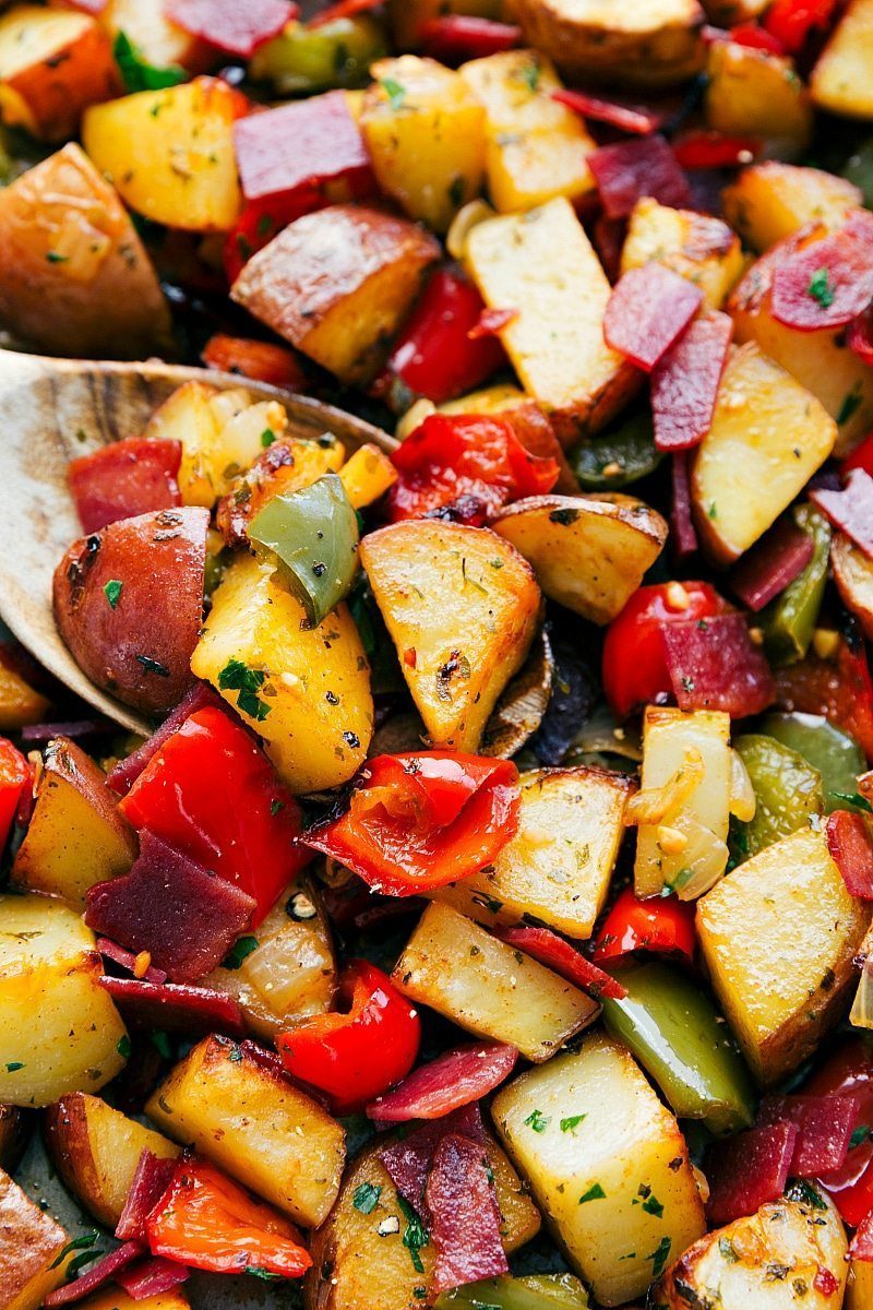 Crispy breakfast potatoes, bacon, peppers, and onions roasted on a sheet pan.