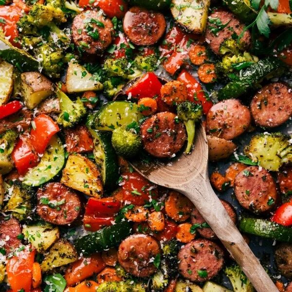 A tray featuring the evenly cooked and seasoned one pan Italian sausage and veggies recipe, where all the flavors come together to create the reliable combination of flavor and texture.