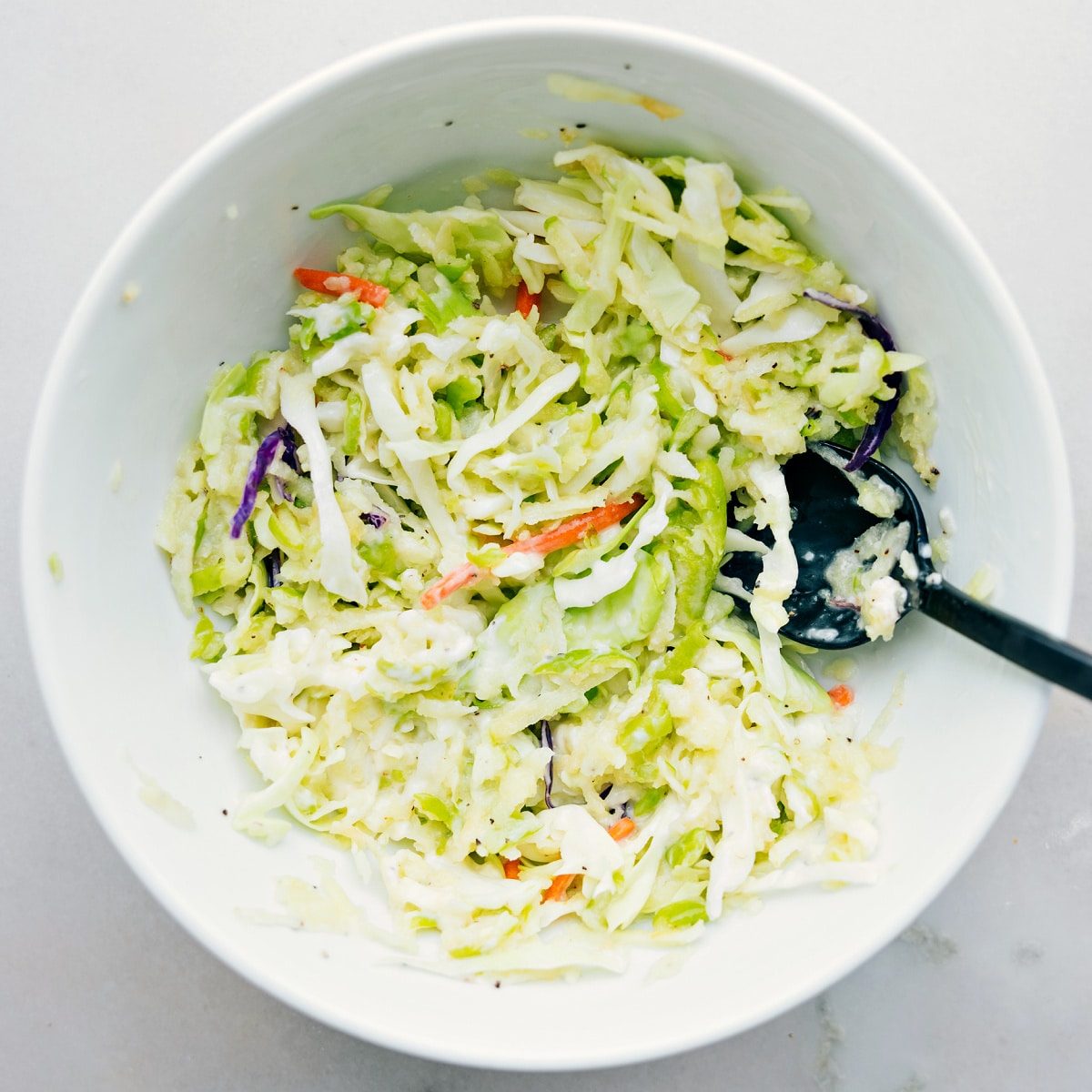 Mixing together the coleslaw mixture to fill these burritos.