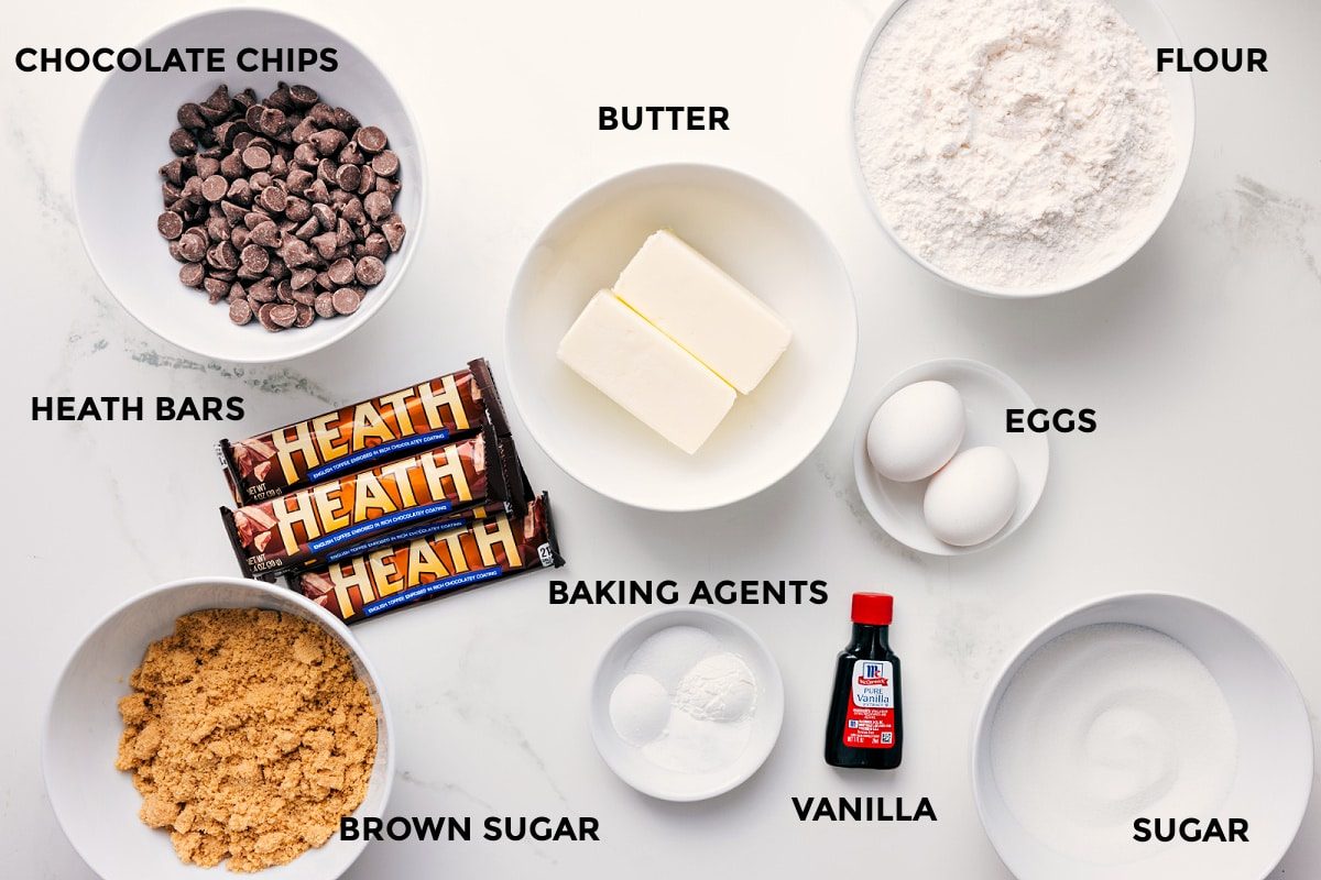 All the ingredients for this recipe for Macadamia Nut White Chocolate Cookies prepped and ready to assemble, including white chocolate, sugars, butter, eggs, flour, and baking agents.