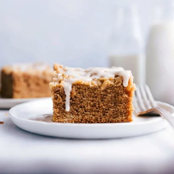 A slice of apple coffee cake on a plate, topped with satisfying frosting.