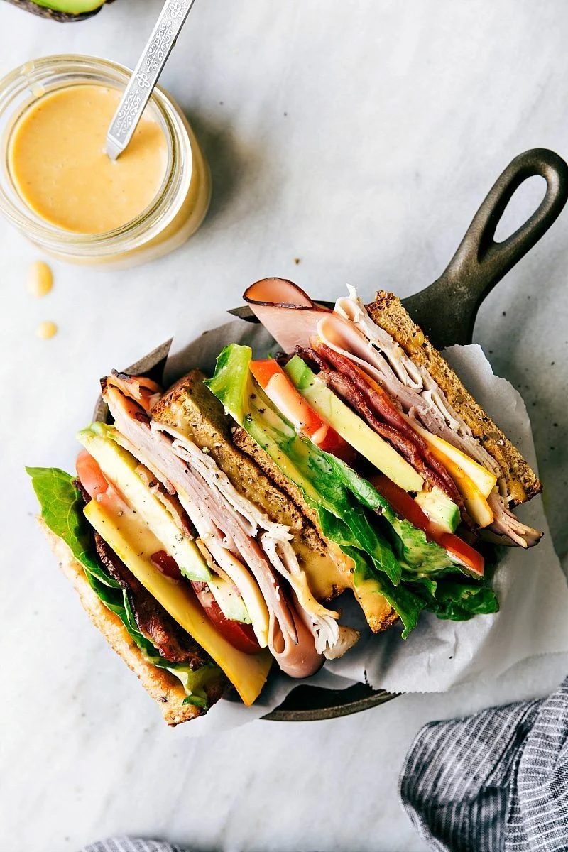 The club sandwich recipe sliced in half to show the different layers.