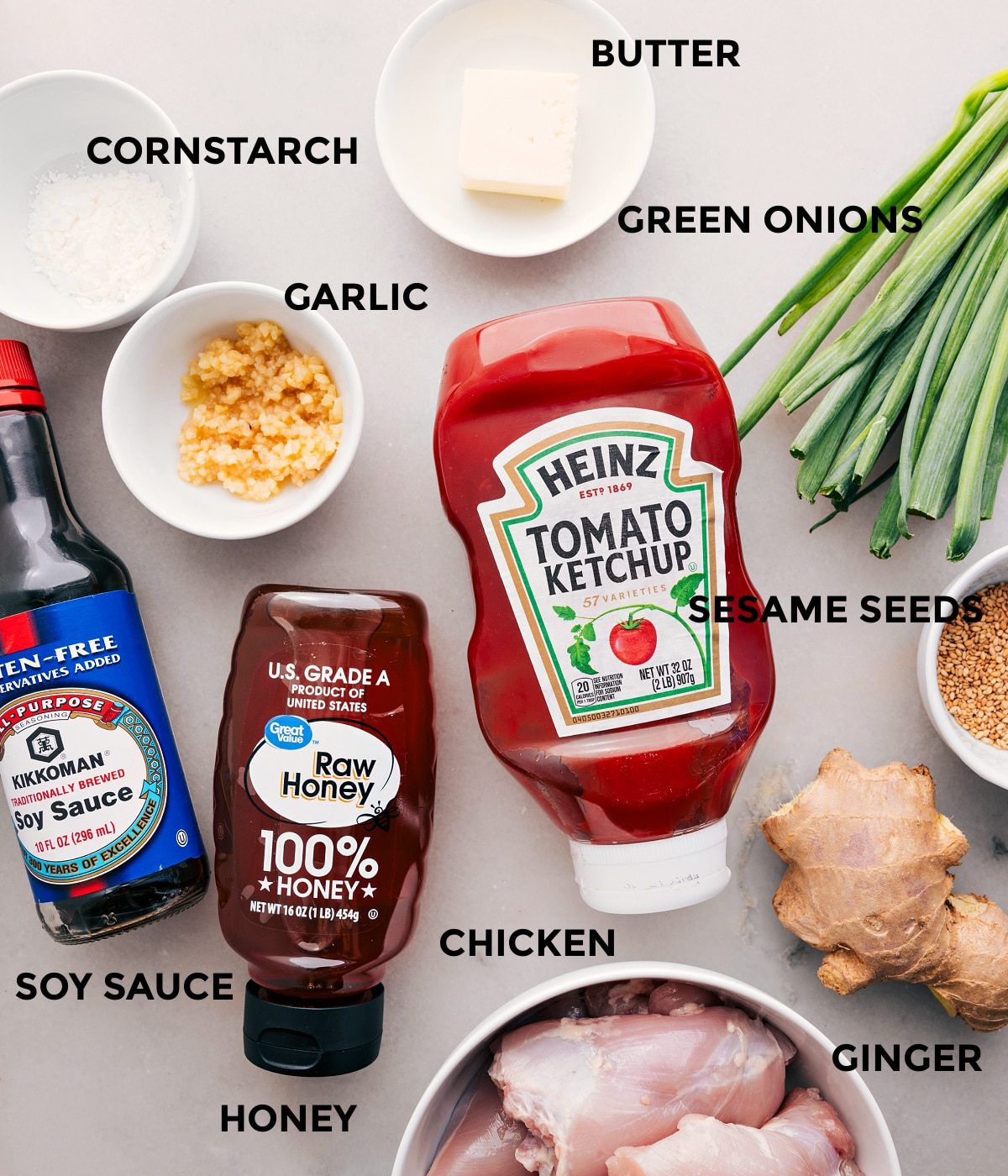 All the ingredients for this recipe, including the meat, butter, green onions, garlic, cornstarch, ketchup, honey, soy sauce, sesame seeds, and ginger, are prepped for straightforward assembly.