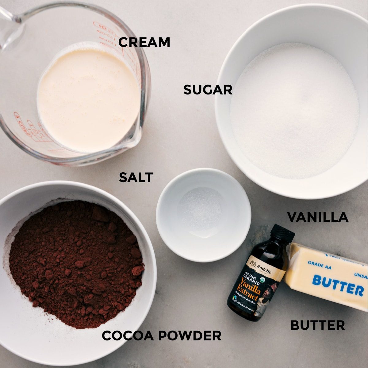 This recipe's ingredients are prepped for straightforward assembly, including sugar, salt, heavy cream, cocoa powder, vanilla, and butter.