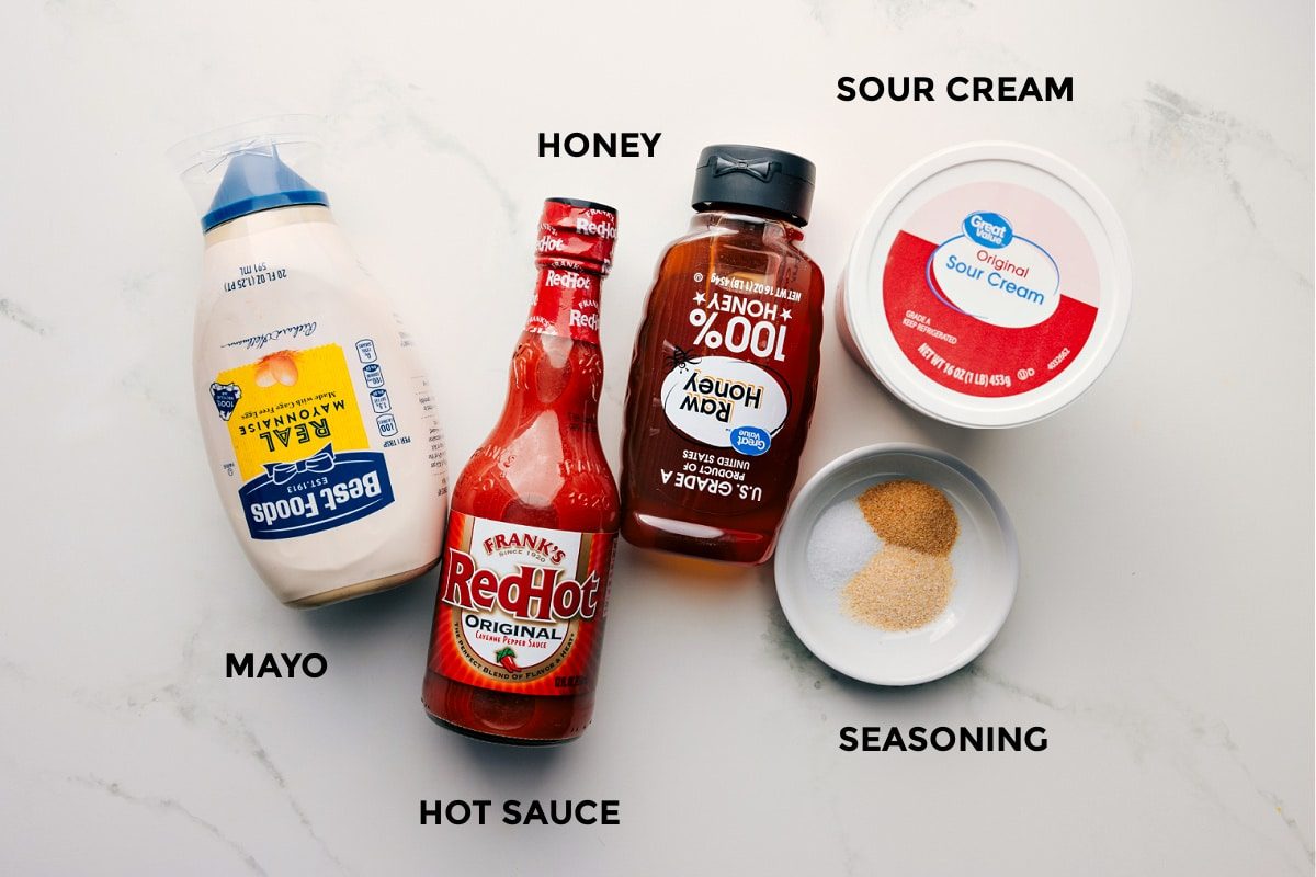 The hot honey chicken salad dressing prepped including the mayo, hot sauce, honey, sour cream, and seasoning.