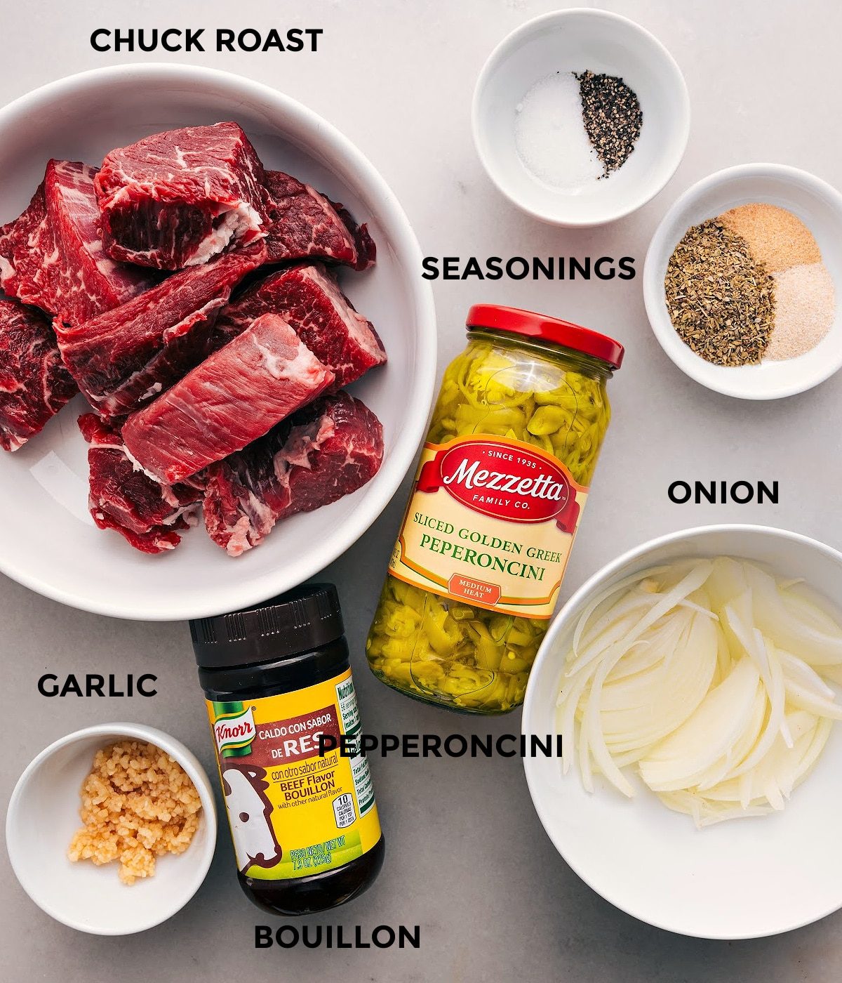 All the ingredients in this recipe are prepped for straightforward assembly, including the meat, pepperoncini, onion, seasonings, garlic, and bouillon.