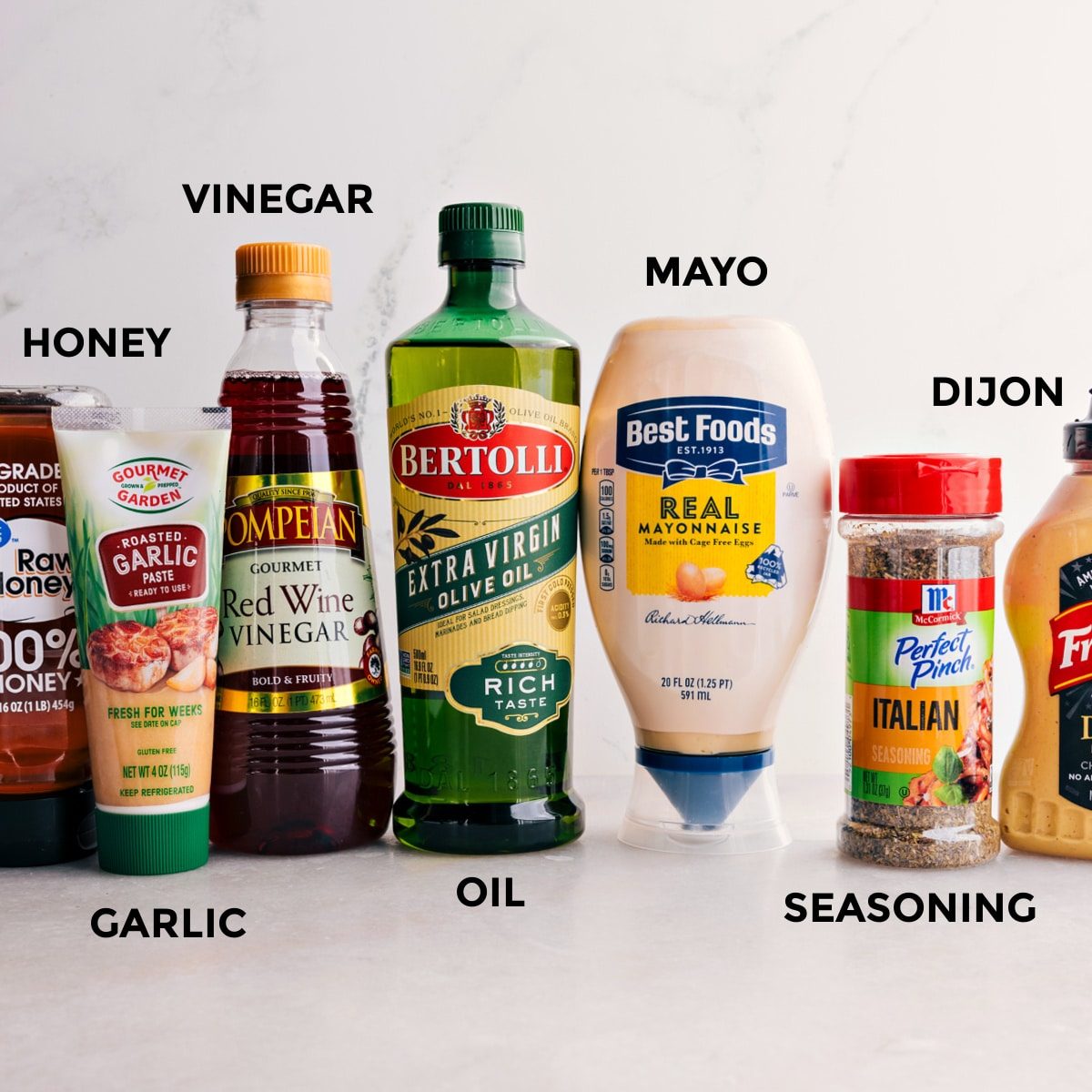 All the dressing ingredients for this Italian Grinder Pasta Salad are prepped for straightforward mixing—honey, garlic, vinegar, oil, mayo, seasoning, and Dijon.