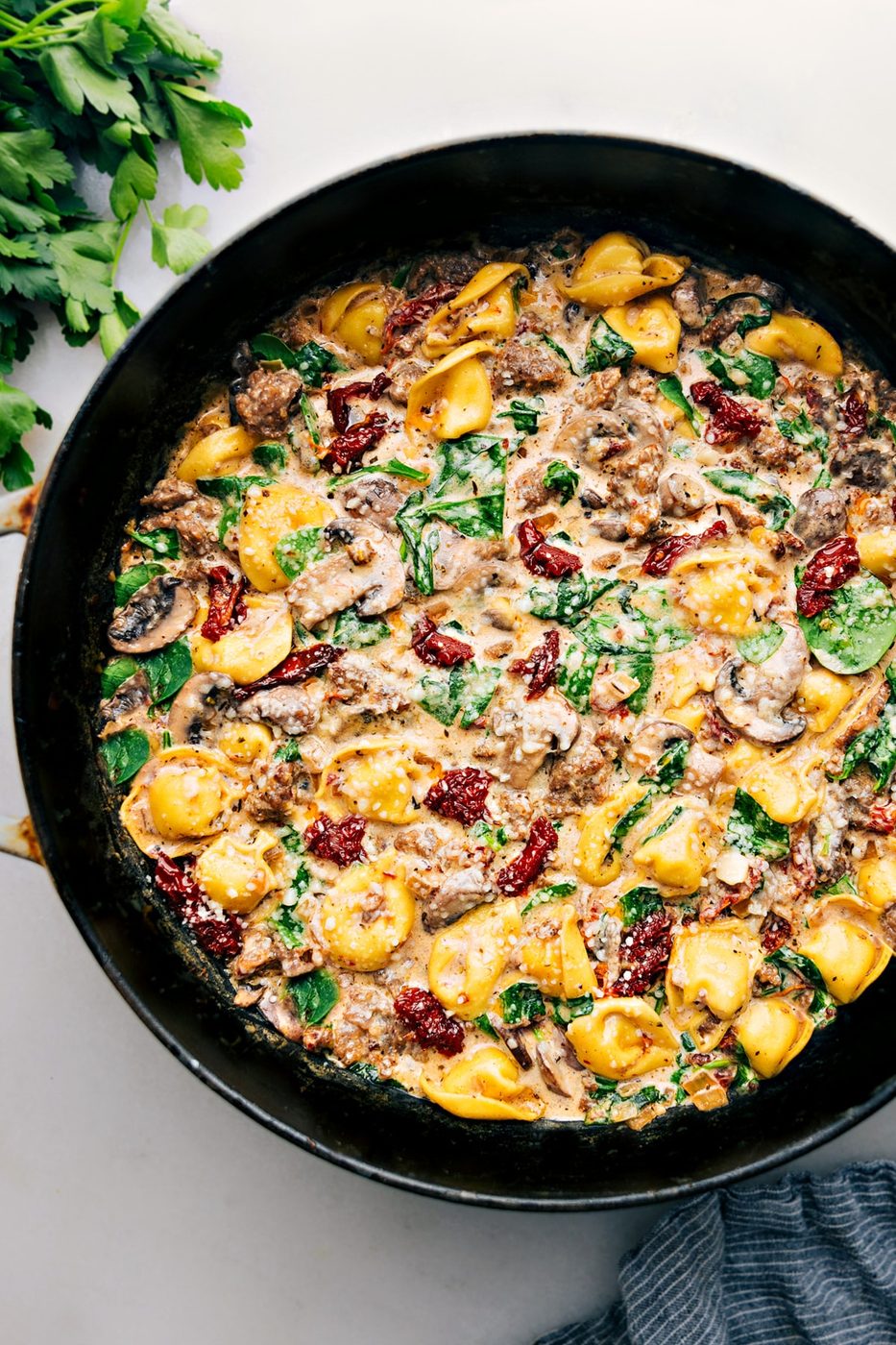 Tortellini bake with sausage, cheese tortellini, creamy sauce, and melted cheese.