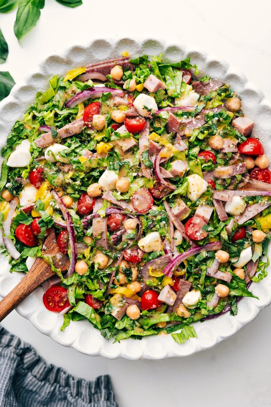 Fresh chopped salad loaded with salami, ham, chickpeas, mozzarella, pepperoncini, basil, and lemon dressing.