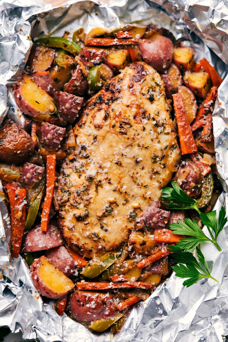 Italian recipes chicken and veggies foil pack with seasoned chicken and vegetables.