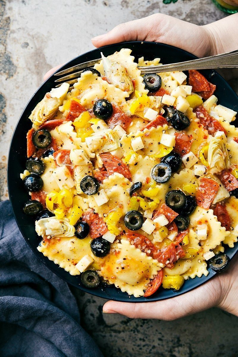 Italian recipes ravioli salad with cheese ravioli, pepperoni, provolone, artichokes, olives, and dressing.