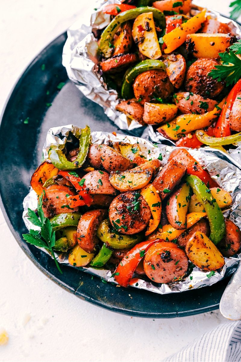Italian recipes foil pack sausage and veggies with peppers, mushrooms, potatoes, garlic, and onions.