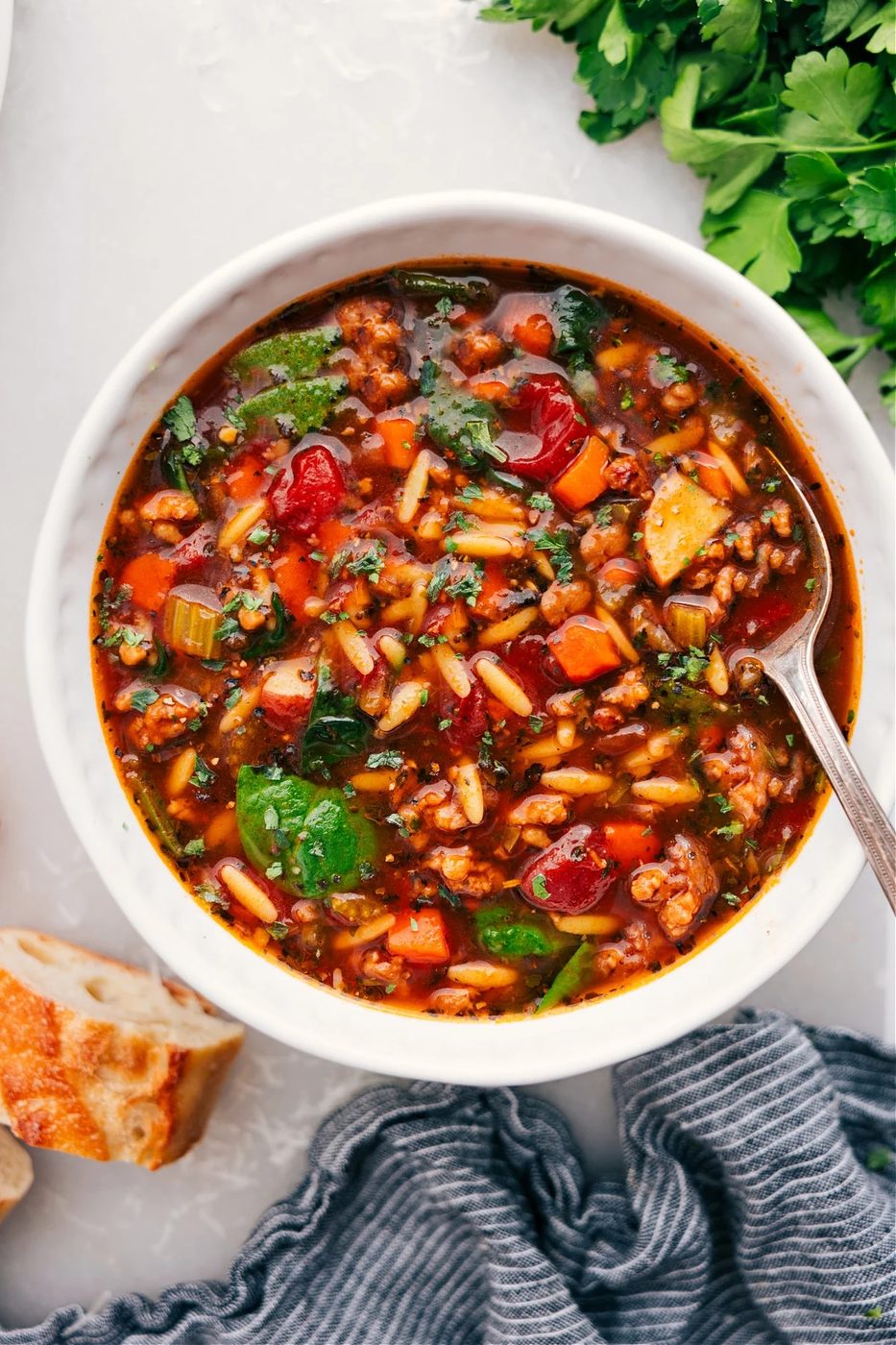 Orzo soup with sausage, fresh vegetables, tender pasta, and Parmesan.